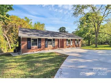 Well-maintained brick home with a manicured lawn and long concrete driveway at 680 Lakeside Dr, Rock Hill, SC 29730