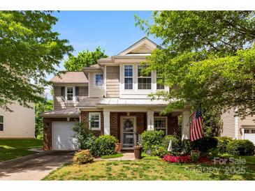 Charming two-story home featuring a brick and siding facade, a welcoming porch, and lush landscaping at 12319 Cumberland Cove Dr, Charlotte, NC 28273