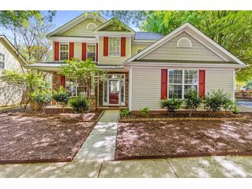 Charming two-story home with red shutters, stone accents, and a well-manicured front yard at 13206 Meadowmere Rd, Huntersville, NC 28078