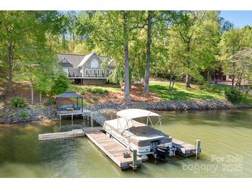 Stunning waterfront home featuring a private dock, boat, and serene lake views at 234 Winding Shore Rd, Troutman, NC 28166