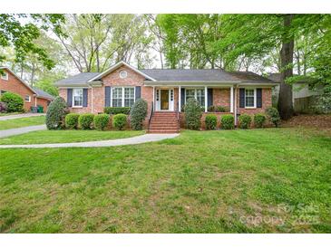 Charming brick home with manicured front lawn and mature landscaping creating excellent curb appeal at 2429 Sugar Mill Rd, Charlotte, NC 28210