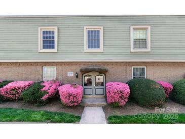 Attractive exterior shot featuring flowering shrubs, windows, and brick accents at 2630 Park Rd # H, Charlotte, NC 28209