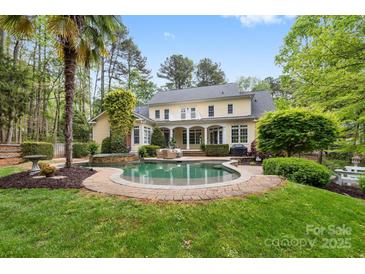 An inviting backyard featuring a refreshing pool and patio surrounded by lush landscaping at 4525 Island Waters Dr, Denver, NC 28037