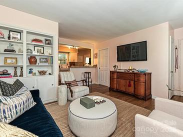 Inviting living room with a plush blue sofa, unique round ottoman, and built-in shelving at 557 Wakefield Dr # A, Charlotte, NC 28209