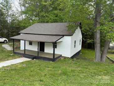 Charming one-story home with a covered porch and a lush, green yard at 59 Pine St, Great Falls, SC 29055