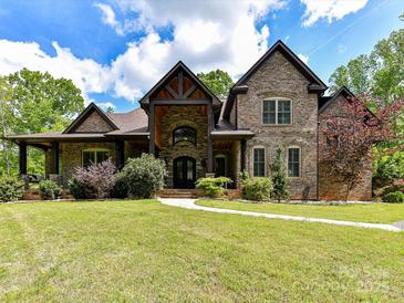 Stunning brick home with beautiful landscaping and a winding walkway leading to the front door at 633 Elmhurst Dr, Fort Mill, SC 29715