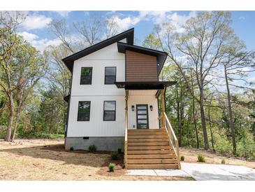 Modern two-story home with a minimalist design, natural wood accents, and a welcoming front porch and yard at 1314 Eddie St, Gastonia, NC 28054