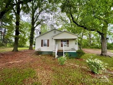 Charming single-story home featuring a covered porch and mature trees in a lush yard at 14600 Glendale Dr, Huntersville, NC 28078