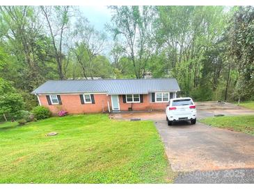 Charming brick home with a metal roof, black shutters, and a well-maintained lawn at 2116 Dana Pl, Shelby, NC 28152