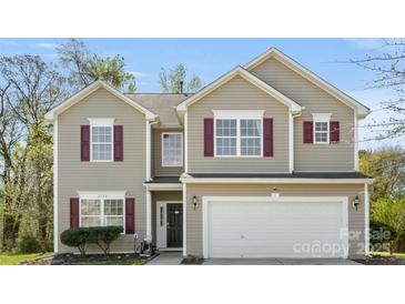 Charming two-story home featuring a two-car garage, neutral siding, and attractive red shutters at 2120 Turtle Point Rd, Charlotte, NC 28262