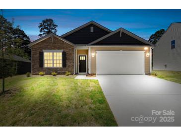 Charming home exterior with stone accents, a two-car garage, and manicured lawn at 3664 Mercer St, Terrell, NC 28682