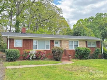 Charming brick home with a well-maintained front yard featuring colorful flowers and lush greenery at 6401 Montpelier Rd, Charlotte, NC 28210
