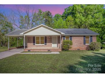 Charming brick ranch home with a covered carport, inviting curb appeal, and landscaped front yard at 700 Fine Wright Ave, York, SC 29745