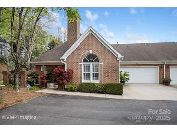 Charming brick home featuring an attached two-car garage and well-manicured landscaping at 7444 Hurstbourne Green Dr, Charlotte, NC 28277