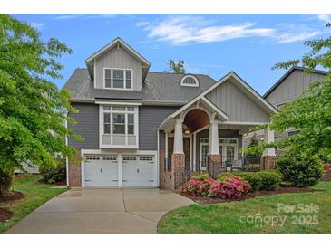 Charming two-story home with a well-manicured lawn, attached two-car garage, covered porch, and neutral color palette at 911 Naples Dr, Davidson, NC 28036