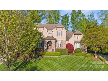 Charming home boasts manicured lawn, stone accents, and mature trees at 9927 Clarkes View Nw Pl, Concord, NC 28027