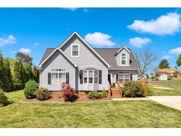 Charming two-story home featuring gray siding, a well-manicured lawn, and a welcoming front porch at 126 Top Flite Dr, Statesville, NC 28677
