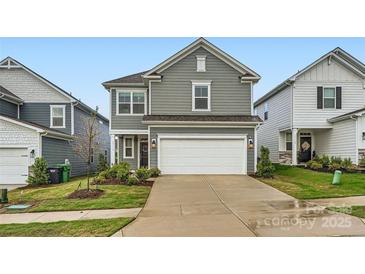 Charming gray two-story home with a two-car garage and well-manicured front yard at 15116 Caspian Way, Charlotte, NC 28278