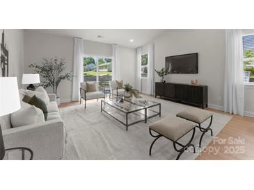 Bright living room featuring large windows and sliding glass doors, modern furnishings, and neutral color palette at 3021 Dylan Nw Pl, Concord, NC 28027