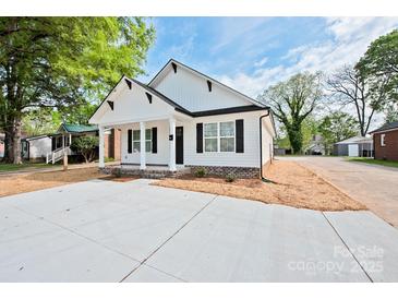 Charming single-story home with a white exterior, black shutters, and a well-manicured front yard at 417 Spring Sw St, Concord, NC 28025