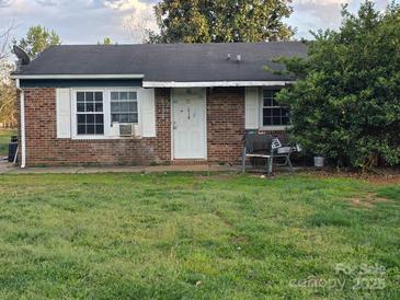 Cozy single-story brick home with a well-maintained lawn and charming white door at 615 Milan E Rd, Charlotte, NC 28216