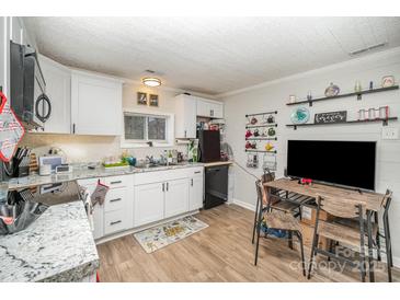 Bright kitchen with white cabinets, granite countertops, and modern appliances offers lots of charm at 705 Sumter St, Lancaster, SC 29720