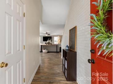 Inviting foyer with wood floors that lead to a sun-lit living room featuring a fireplace at 8604 Cedardale Ridge Ct, Charlotte, NC 28269