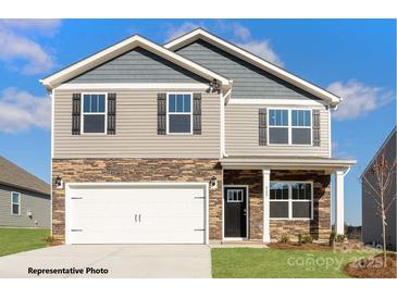 Two-story home featuring stone accents, gray siding, a two-car garage, and well-maintained landscaping at 133 Falling Up Ln, Salisbury, NC 28147