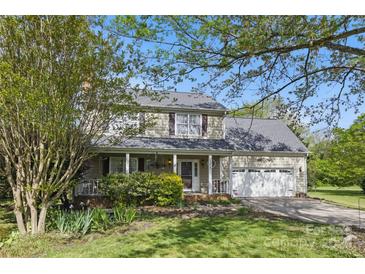 Charming two-story home features a welcoming front porch, attached garage, and well-maintained lawn at 13843 Poppleton Ct, Charlotte, NC 28273