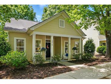 Charming home featuring a cozy front porch with columns and blooming flowers and mature trees at 19416 Fridley Ln, Cornelius, NC 28031