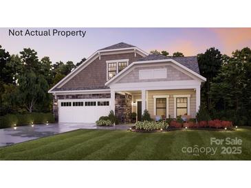 Charming two-story home featuring a manicured lawn, stone accents, a covered porch and an attached two car garage at 2 Five Creek Rd # 2, Charlotte, NC 28213