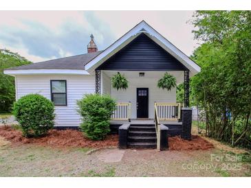 Charming home featuring a cozy front porch with black and white trim and manicured landscaping at 409 N Apple St, Gastonia, NC 28054