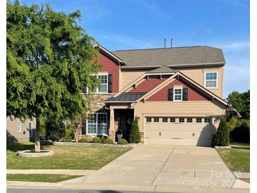 Charming two-story home with a two-car garage, landscaped yard, and a mix of stone and siding accents at 487 Hawks Creek Pkwy, Fort Mill, SC 29708