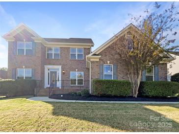 Charming brick two-story home with manicured lawn, beautiful landscaping, and classic architectural details at 5104 Shannamara Dr, Matthews, NC 28104