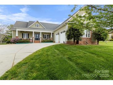 Inviting two-story home boasts a charming porch, two-car garage, and well-manicured lawn at 557 Luther Dr, Iron Station, NC 28080