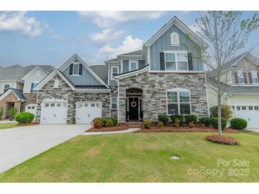 Beautiful two-story home featuring stone accents, a manicured lawn, and a two-car garage at 1005 Argentium Way, Waxhaw, NC 28173