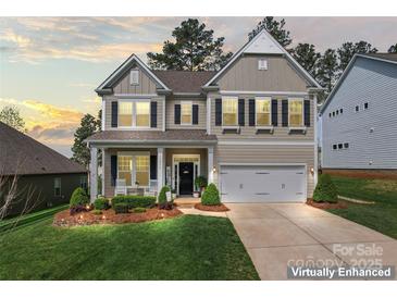 Charming two-story home with a well-manicured lawn, inviting front porch and attached two car garage at 10072 Fox Trotter Ln, Midland, NC 28107
