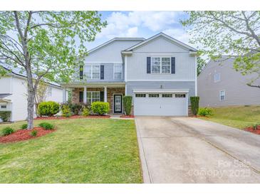 Charming two-story home with a well-manicured lawn, two car garage, and tasteful landscaping at 1144 Spicewood Pines Rd, Fort Mill, SC 29708
