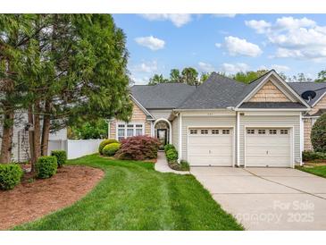 Charming home featuring a two-car garage, well-maintained lawn, and mature landscaping at 141 Ivy Creek Ln, Mooresville, NC 28115