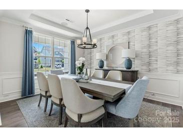 Elegant dining room with modern chandelier, stylish wallpaper, and large window with blue curtains at 167 Glenn Dr, Mooresville, NC 28115