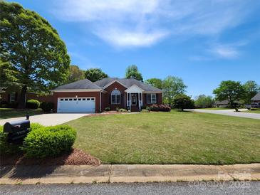 Charming brick home with a manicured lawn, two-car garage, and inviting front porch, perfect for suburban living at 5505 Weavers Row, Gastonia, NC 28056