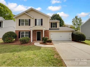Charming two-story home featuring a classic design, attached two-car garage, manicured front lawn, and traditional architectural details at 614 Saratoga Dr, Clover, SC 29710