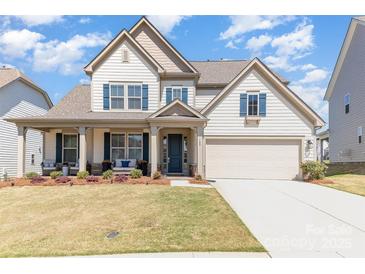 Charming two-story home features a well-manicured lawn, inviting front porch, and attached two car garage at 109 Crossvine Dr, Mooresville, NC 28117