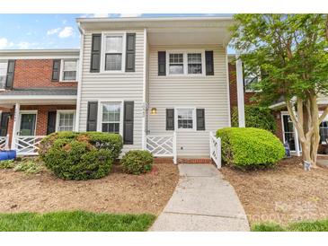 Charming two-story townhome with light siding, dark shutters and green landscaping at 10942 Winterbourne Ct, Charlotte, NC 28277