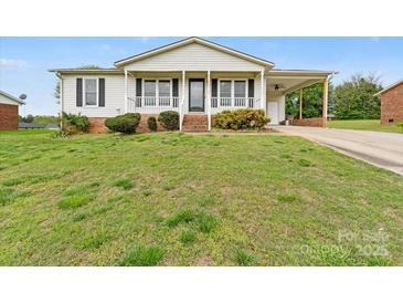 Charming one-story home featuring a covered porch, attached carport, and a well-maintained front lawn at 1504 Andicot Ln, Shelby, NC 28152