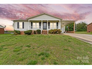 Charming one-story home with a covered porch and carport set on a well-manicured lawn under a dramatic sky at 1504 Andicot Ln, Shelby, NC 28152
