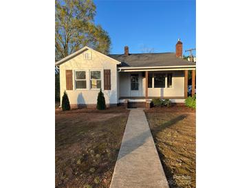 Charming single-story home with a walkway leading to the covered porch entrance at 240 North Ave, Troutman, NC 28166