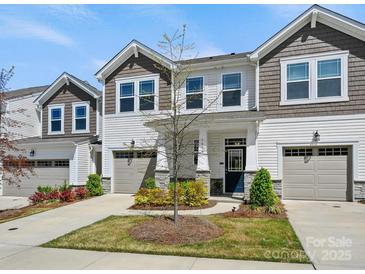Charming two-story townhome with stone accents, attached garages, and well-manicured lawn under a sunny blue sky at 3813 Amalia Pl, Indian Land, SC 29707