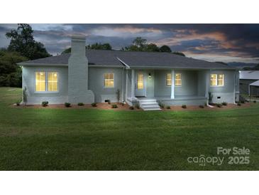 Inviting home exterior featuring a brick facade, covered front porch, and well-maintained landscaping at 4979 Plateau Rd, Vale, NC 28168
