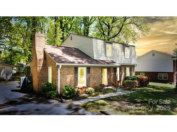 Charming two-story brick home with a well-maintained lawn, lovely landscaping, and shuttered windows at 5623 Eastbrook Rd, Charlotte, NC 28215